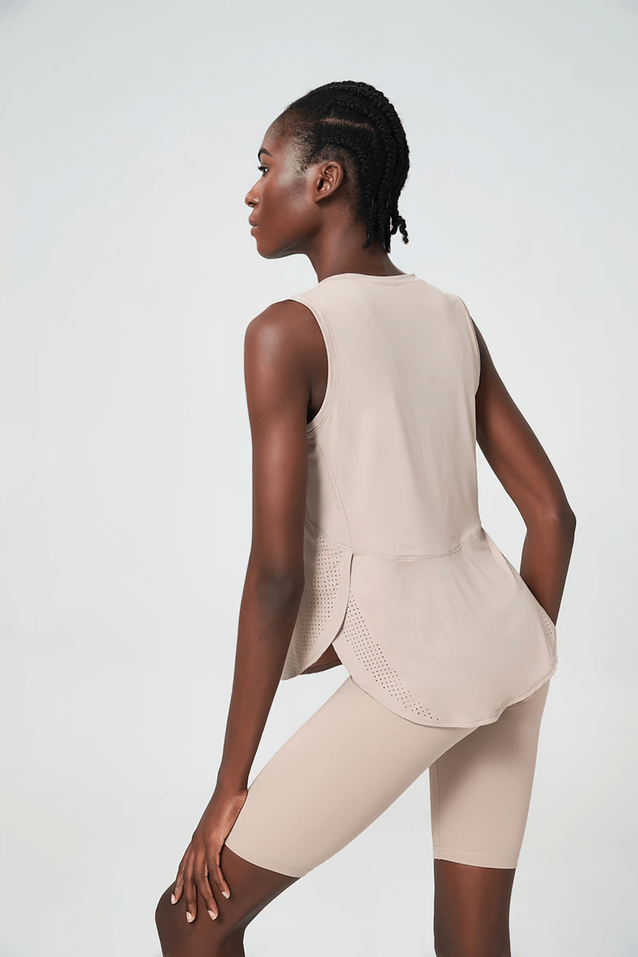 Woman wearing beige running tank top and shorts set, ideal for yoga and running. Stylish activewear for an active lifestyle.